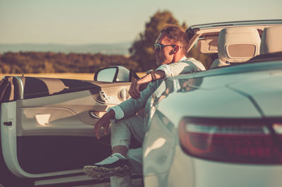 Side view of young woman taking car