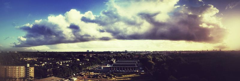 Aerial view of cityscape against cloudy sky