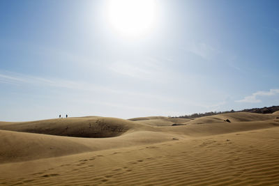 Scenic view of desert against blue sky