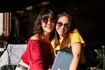 Portrait of smiling young woman using mobile phone