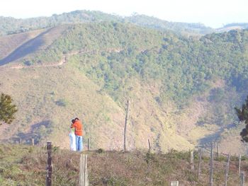 Mid distance view of couple embracing against mountains