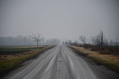 Road amidst trees against sky