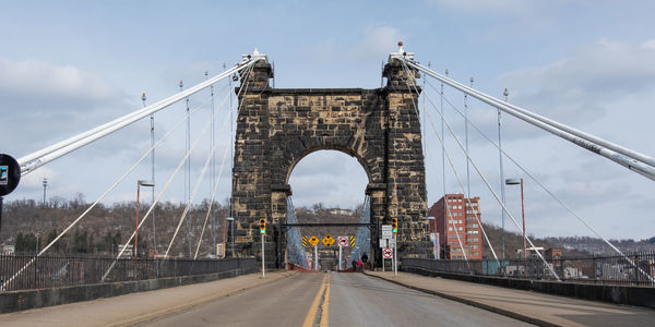 View of suspension bridge against cloudy sky