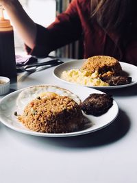 Midsection of woman having food at table in restaurant