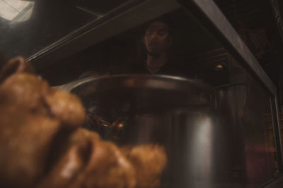 Reflection of people on mirror in kitchen