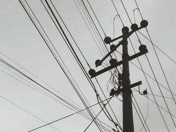 Electricity pole and power lines against clear sky