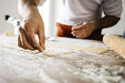 Midsection of male chef preparing food on table