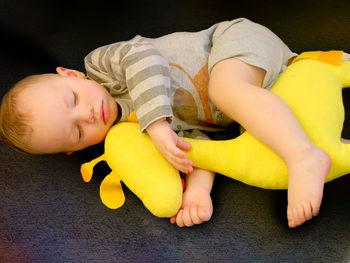 Portrait of cute baby boy sitting on sofa at home