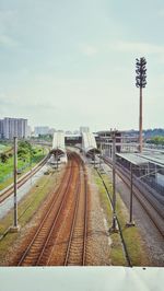 Railroad tracks in city against sky