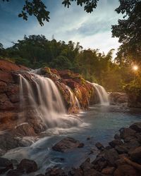 Scenic view of waterfall against sky