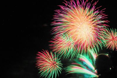 Low angle view of firework display at night