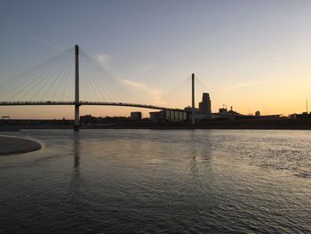 Footbridge over river during sunset