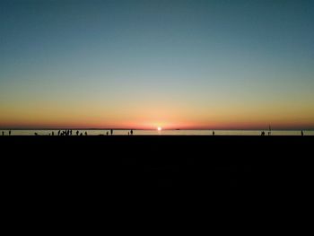 Scenic view of beach against clear sky during sunset