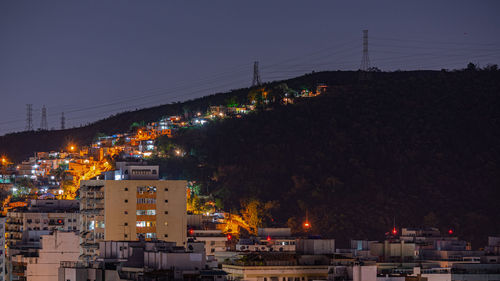 Illuminated buildings against sky at night