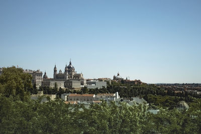 Townscape amidst trees against clear sky