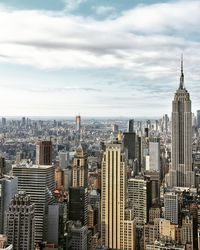 View of cityscape against cloudy sky