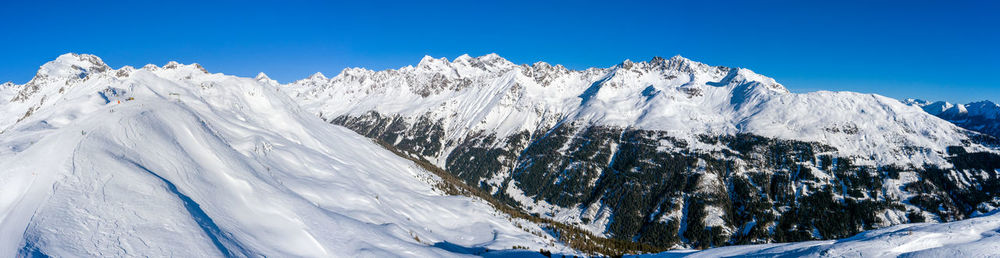 Scenic view of snowcapped mountains against blue sky