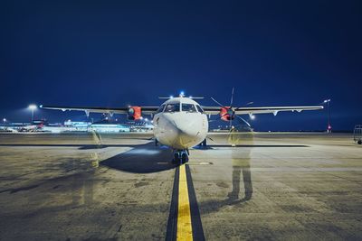 Low angle view of airplane flying against sky at night