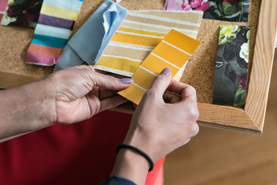 Cropped hands of businesswoman holding color swatches in home office
