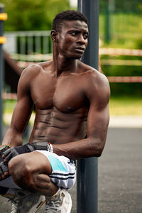 Shirtless man exercising in park