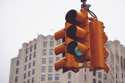 Low angle view of road signal against buildings in city