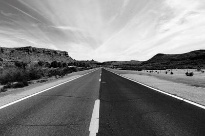 Road by mountain against sky