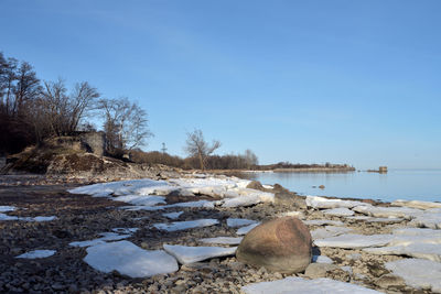 Scenic view of snow covered land against clear blue sky