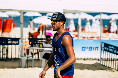 Young man wearing sunglasses standing on beach