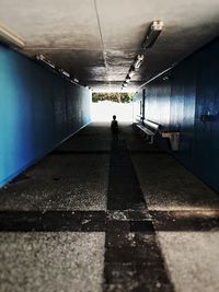 Man walking in illuminated underground walkway