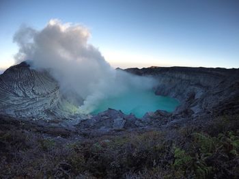 Smoke emitting from volcanic mountain against sky