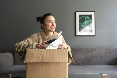 Portrait of smiling young man sitting on sofa