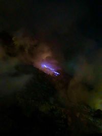 Low angle view of illuminated lights against sky at night