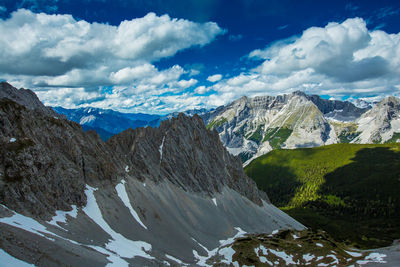 Scenic view of snow covered mountains against cloudy sky