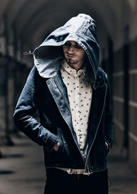 Man wearing hooded jacket standing in city