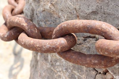 Close-up of rusty chain on rock