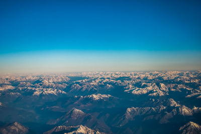 Aerial view of dramatic landscape against blue sky