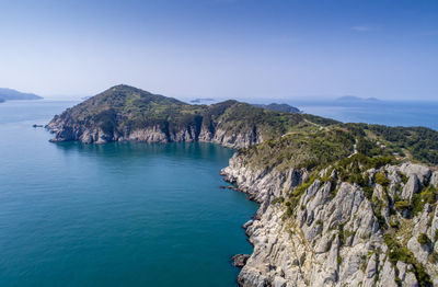 Scenic view of sea and rocks against blue sky