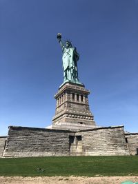 Low angle view of statue against blue sky