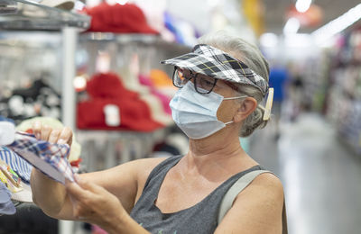 Senior woman with mask shopping