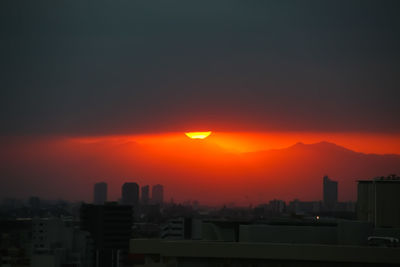 Silhouette buildings against sky during sunset