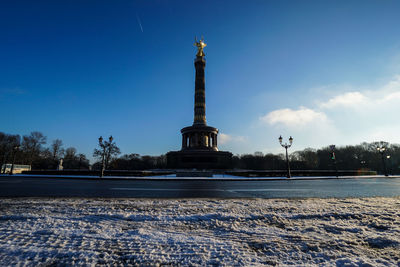 Low angle view of victory column against sky during winter