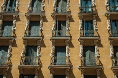 Old building with colorful facade and closed windows with iron balustrade in madrid, spain.