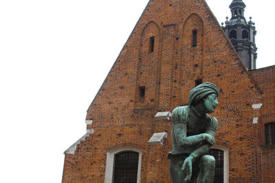 Low angle view of statue against building against sky