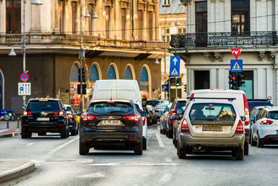 Cars on city street by buildings