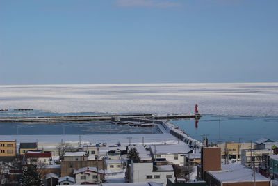 High angle view of buildings by sea against sky