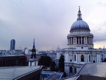 Buildings in city against cloudy sky