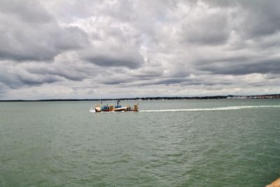 Boat sailing in sea against sky