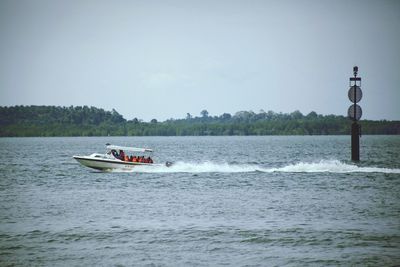 Boat sailing in sea against clear sky