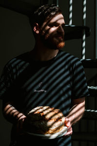 Midsection of man holding ice cream at home