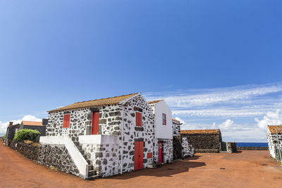 Houses by sea against blue sky